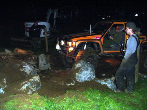 1993 Ford Bronco - Off-road vehicle attempts to clear rocks at night, with an excavator nearby.