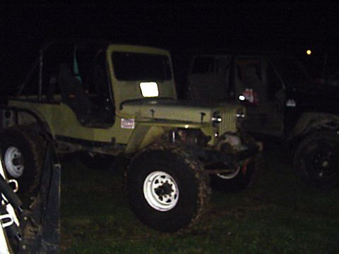 1993 Ford Bronco - Two off-road vehicles are parked outdoors at night, with one Jeep CJ prominently in the foreground.
