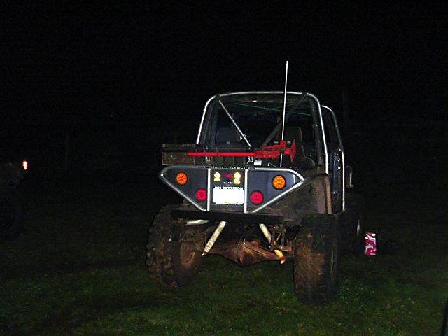 Rear view of off-road SUV with custom bumper, roll cage, and spare tire carrier