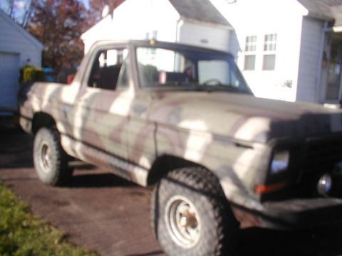 1979 Ford Bronco - This SUV is painted in a camouflage pattern, obscuring its specific make and model details.