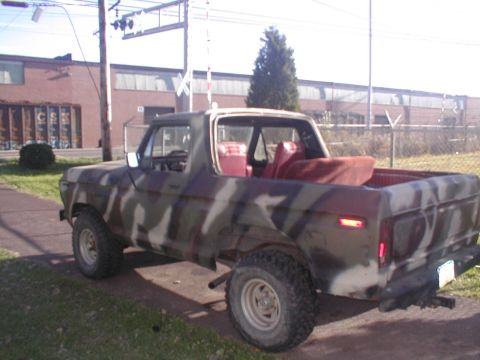 1979 Ford Bronco - This 1979 Ford Bronco features a camouflage paint job and a red interior, seen from a 3/4 front angle.