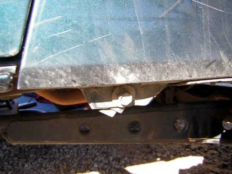 1995 Ford Bronco - The underside of a vehicle shows wear and tear on the frame and body.