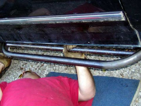 1995 Ford Bronco - Close-up view of side step bars installed on a black vehicle.
