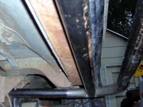 1995 Ford Bronco - Close-up view of a vehicle's undercarriage, showing exposed metal components and protective bars.