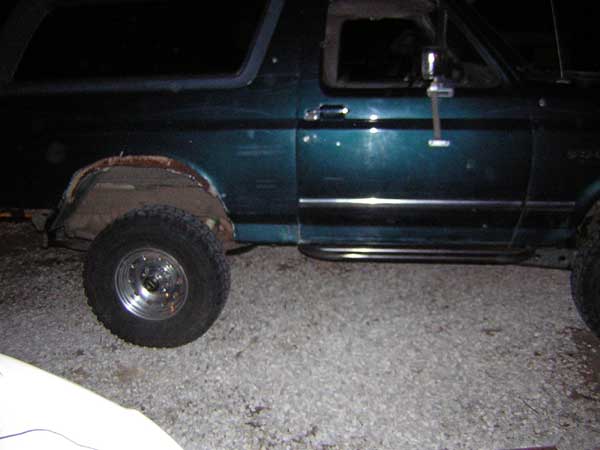 Teal SUV side view showing fender damage and aftermarket steps