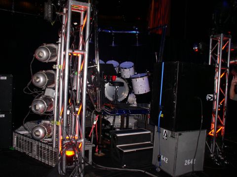 1990 Ford Bronco - A stage setup a lighting truss with multiple spotlights and a drum kit ready for a performance.