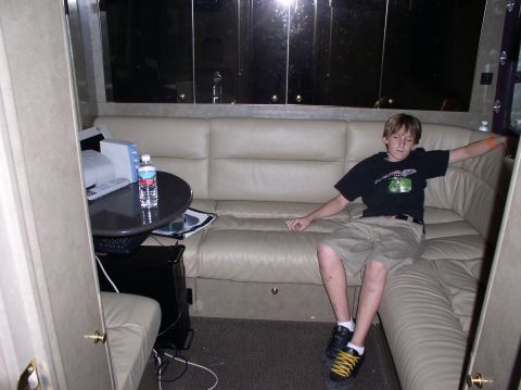 1990 Ford Bronco - Interior view of an RV with a young person relaxing on the couch next to a table.