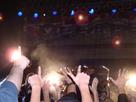 1990 Ford Bronco - Hands are raised in a concert venue with stage lights and smoke in the background.