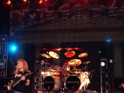 1990 Ford Bronco - A full drum kit with cymbals and "MEGADETH" branding is set up on a concert stage.