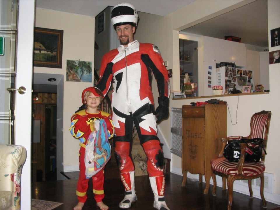 Adult and child in matching red and white racing suits stand in a house