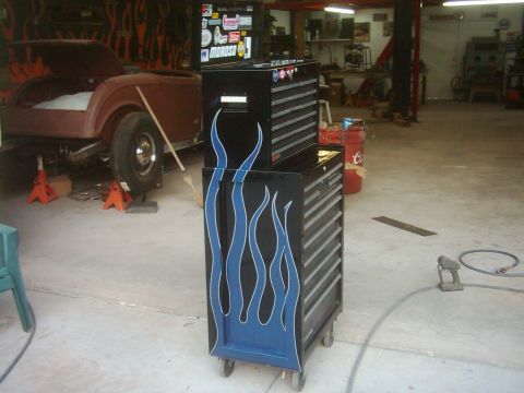 1978 Ford Bronco - A black toolbox with blue flame graphics sits in a garage.