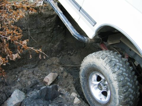 1985 Ford Bronco - Close-up of a 1985 Ford Bronco's tire navigating a dirt ditch.