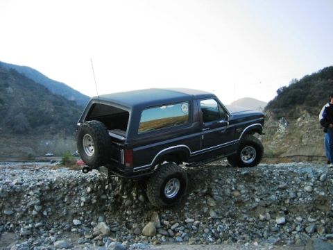 1985 Ford Bronco - This Ford Bronco is navigating a rocky incline, its off-road capabilities.
