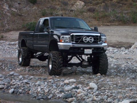 2000 Ford F-450 - Modified 2000 Ford F-450 Super Duty pickup truck with custom grille and off-road tires.