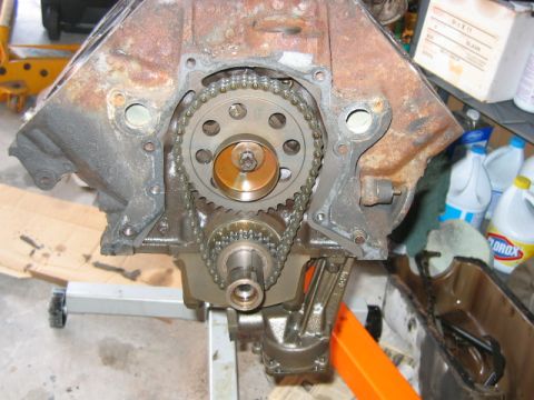 1992 Ford Bronco - Close-up of an engine block front with the timing cover removed, showing the timing chain connecting the camshaft sprocket and crankshaft g…