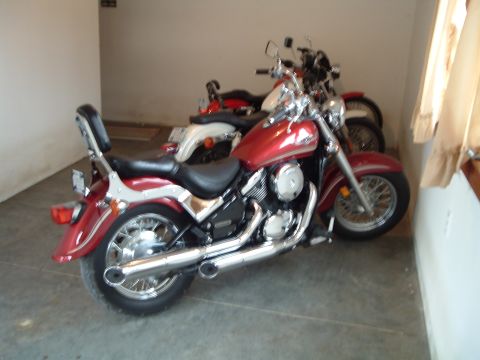 1995 Mercury Grand Marquis - Two motorcycles are parked in a garage or storage area.