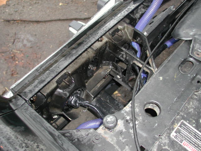 Stripped front core support with wiring and purple loom, headlight removed