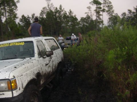 1989 Ford Bronco - Several off-road vehicles are stuck in the mud during an event.