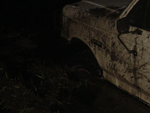 1989 Ford Bronco - This vehicle appears to be stuck in a muddy, overgrown area at night.