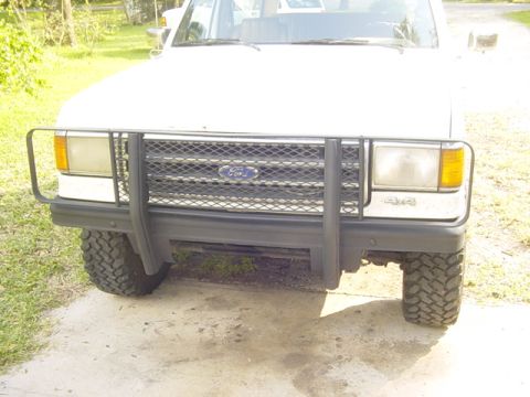 1989 Ford Bronco - Front view of a white 1989 Ford Bronco, equipped with a brush guard and 4x4 badging.