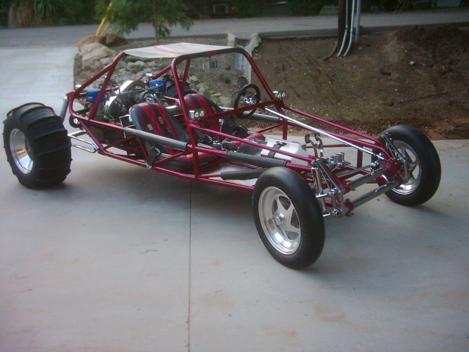 Red dune buggy with sand tires on rear and custom wheels on front