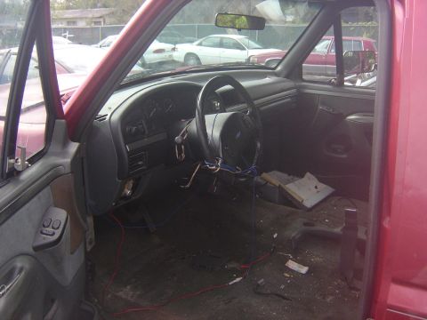 1993 Ford Bronco - Interior view of a red 1993 Ford Bronco, showing the dashboard and passenger side.