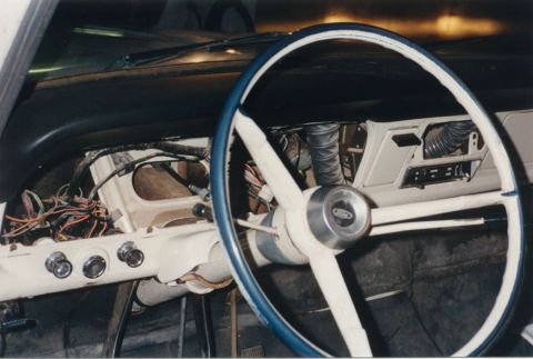1968 Ford F-100 - Dash of a classic Ford pickup mid-teardown, with the instrument cluster and radio removed to expose the wiring harness, defroster ducting a…