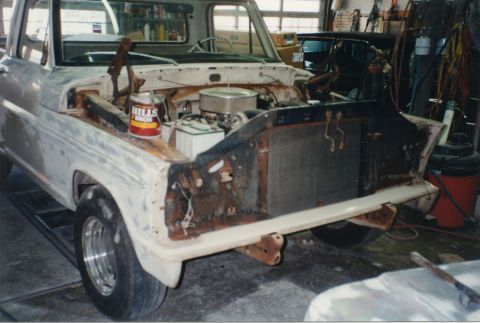 1968 Ford F-100 - Right front three-quarter view of a classic Ford pickup in a garage with the front sheet metal removed, no hood, fenders or grille, exposin…