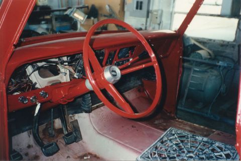 1968 Ford F-100 - Interior of a classic Ford pickup during reassembly, with the dash, steering wheel, column and door panel all painted bright red and the in…