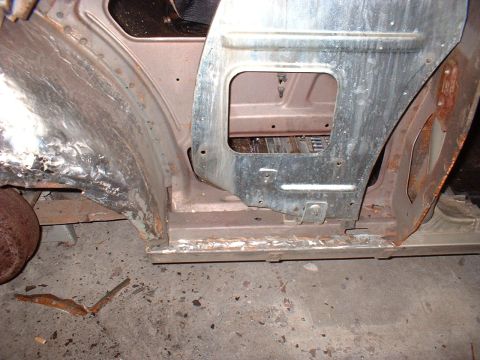 1971 Ford Torino - Close-up view of a car's door frame and rocker panel, revealing areas of rust and recent welding repairs.