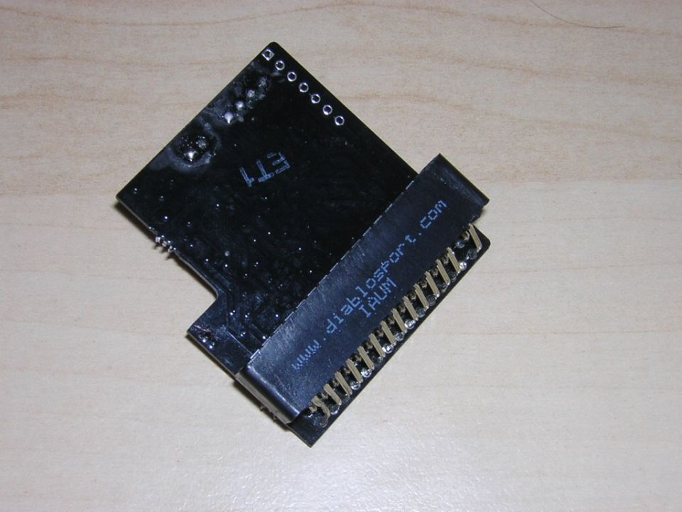 Underside of a black tuning chip board with edge connector reading diablosport.com