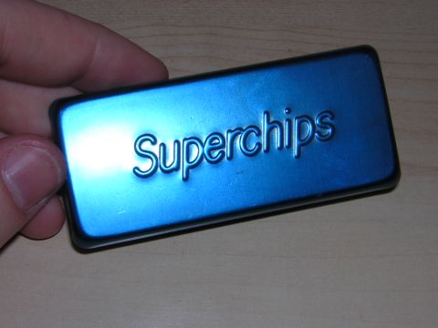 1998 Ford Crown Victoria - hand holds a black-edged module with a blue metallic face embossed with the word Superchips.