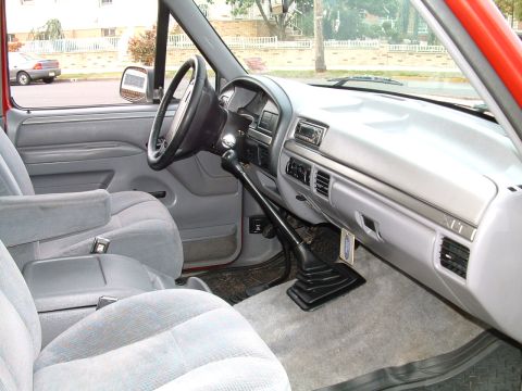 1994 Ford Bronco - The interior of this Ford Bronco features grey cloth seats and a manual transmission shifter.