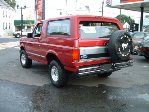 1994 Ford Bronco - Rear view of a red 1994 Ford Bronco with a spare tire cover.