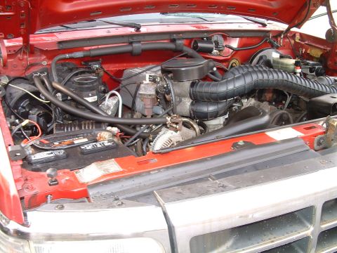 1994 Ford Bronco - Close-up view of the engine compartment, showing various components and the battery.