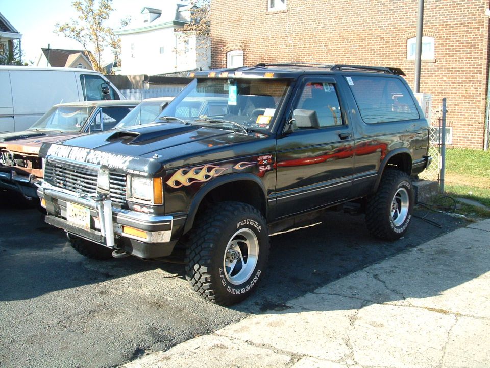 Black lifted SUV with flame decals and custom hood scoop