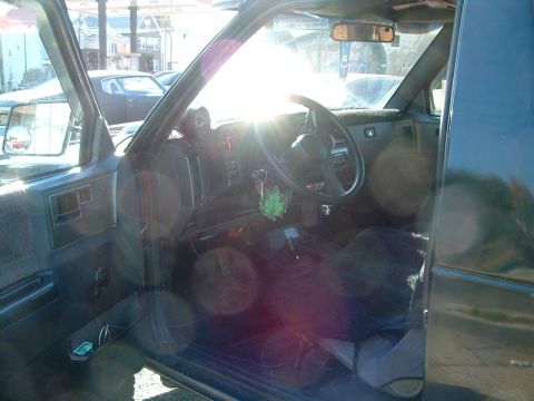 1994 Ford Bronco - Interior view of a truck, with sunlight creating lens flare across the dashboard and steering wheel.
