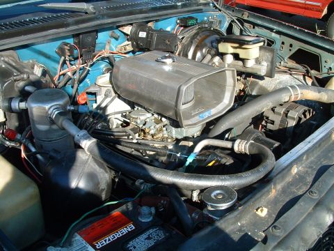 1994 Ford Bronco - The engine bay features an aftermarket air intake system and various hoses and components.