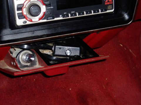 1990 Ford Bronco - Interior dash detail of a truck with a red console and red carpet, showing an aftermarket 50W x 4 CD head unit above an open storage cubby…