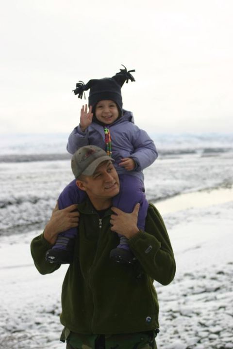 1985 Ford Bronco - A father carries his child on his shoulders in a snowy landscape. The child waves to the camera.