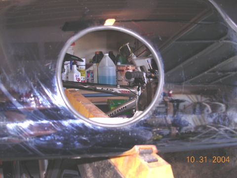 2004 Ford F-250 - A circular reflection reveals a cluttered workshop with various items on shelves.