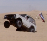 1967 Ford Bronco - 1967 Ford Bronco kicking up sand while driving off-road.