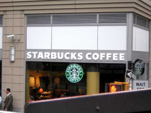 1995 Ford Bronco - A Starbucks Coffee storefront with its iconic logo and signage is visible.
