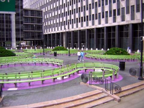1995 Ford Bronco - An urban plaza features winding green benches with purple ground accents, set against a backdrop of a large, modern office building.