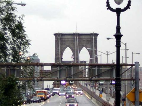 1995 Ford Bronco - Vehicles drive on a bridge under an overcast sky, with the iconic Brooklyn Bridge visible in the distance.