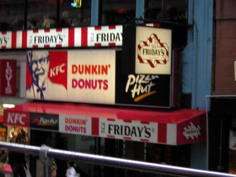1995 Ford Bronco - Multiple fast-food restaurant signs are visible on a building facade.