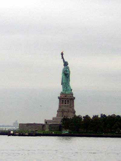 1995 Ford Bronco - The Statue of Liberty stands tall against a cloudy sky, with water in the foreground.