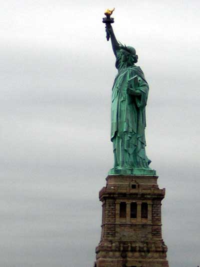 1995 Ford Bronco - The Statue of Liberty stands tall against an overcast sky, her torch raised high.