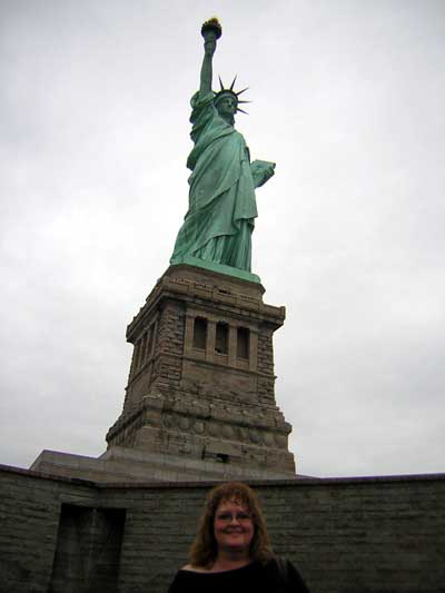 1995 Ford Bronco - A woman stands in front of the Statue of Liberty on a cloudy day.