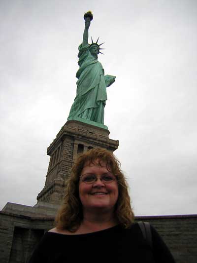 1995 Ford Bronco - A woman poses for a photo in front of the Statue of Liberty on an overcast day.